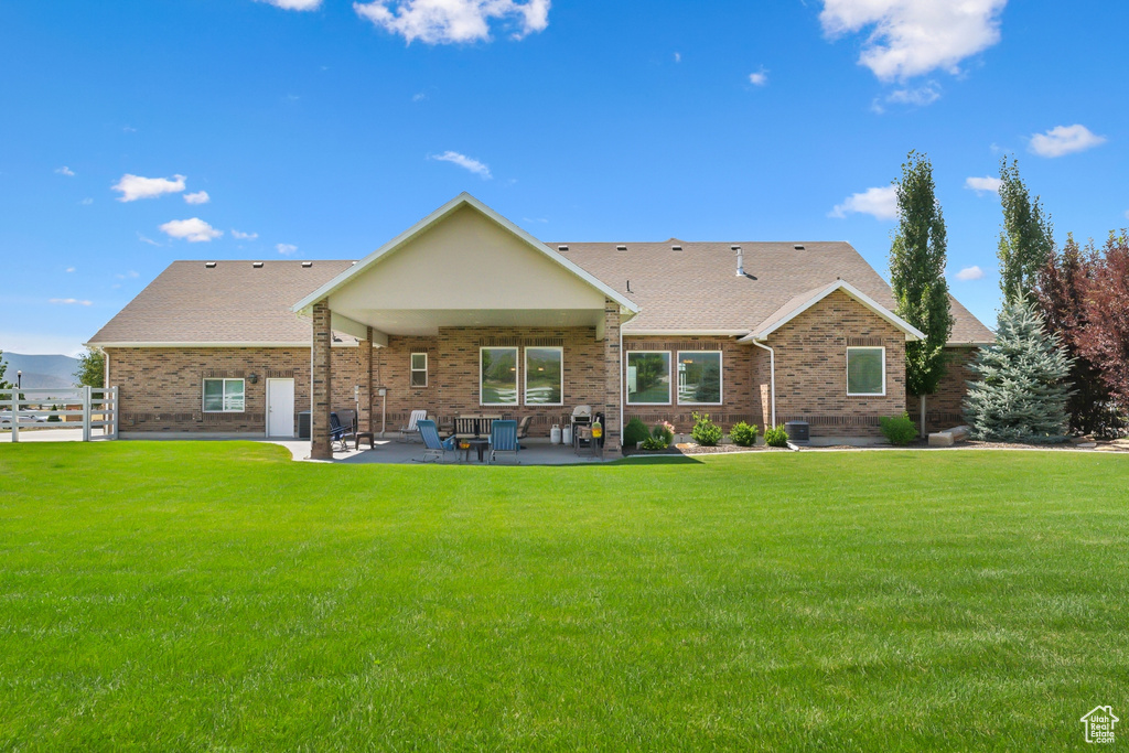 Rear view of property featuring a patio area, cooling unit, and a yard