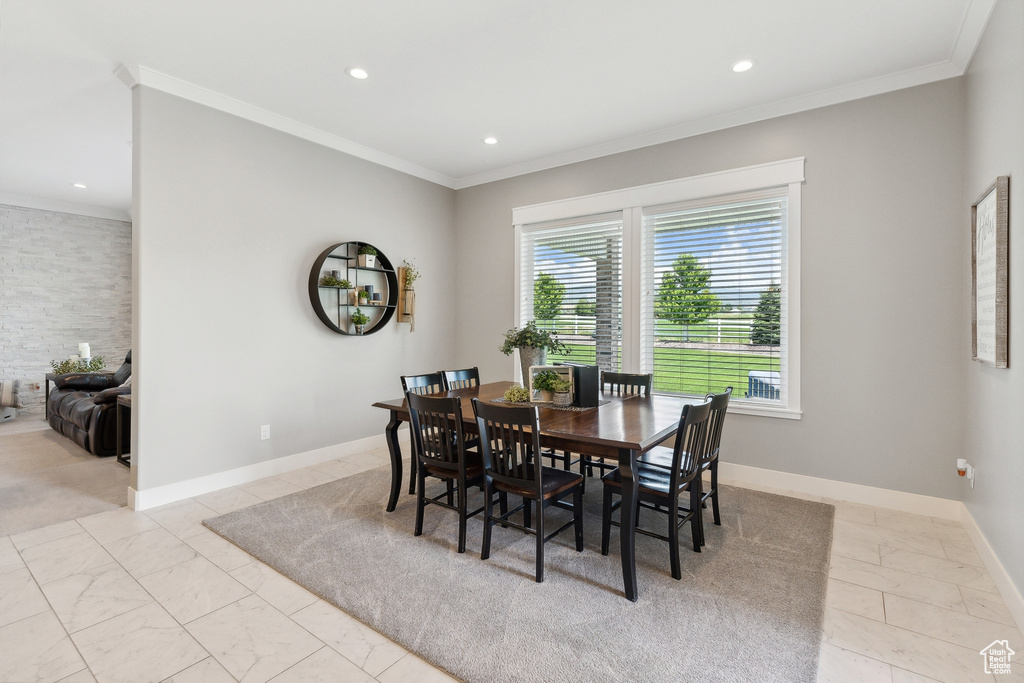 Dining room with ornamental molding and light tile patterned floors