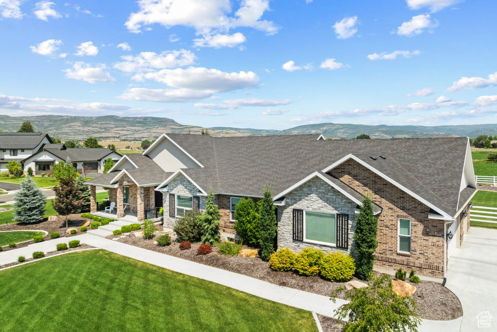 View of front of home featuring a front lawn and a mountain view