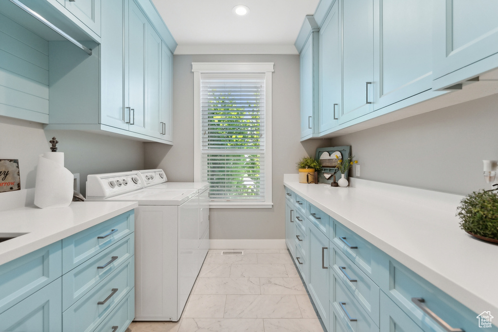 Washroom with washing machine and dryer, cabinets, and light tile patterned floors