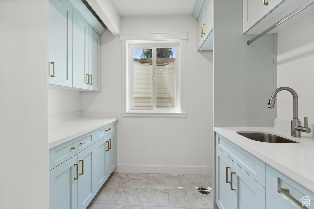 Laundry room with light tile patterned floors and sink