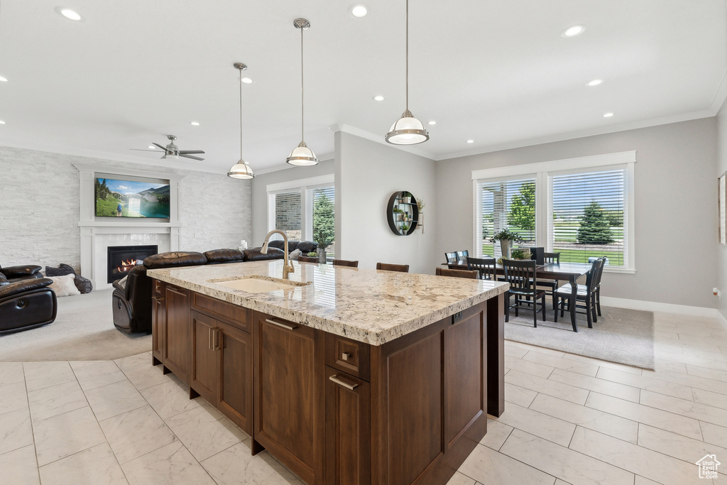 Kitchen featuring sink, pendant lighting, an island with sink, light tile patterned flooring, and ceiling fan