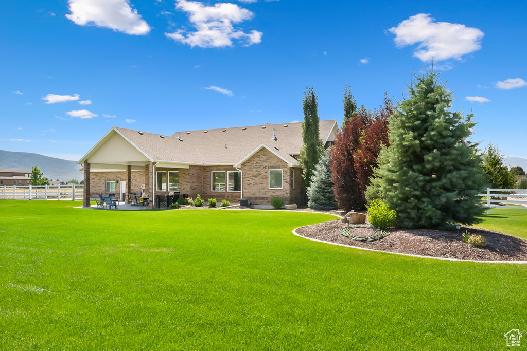 View of front of home with a patio and a front lawn