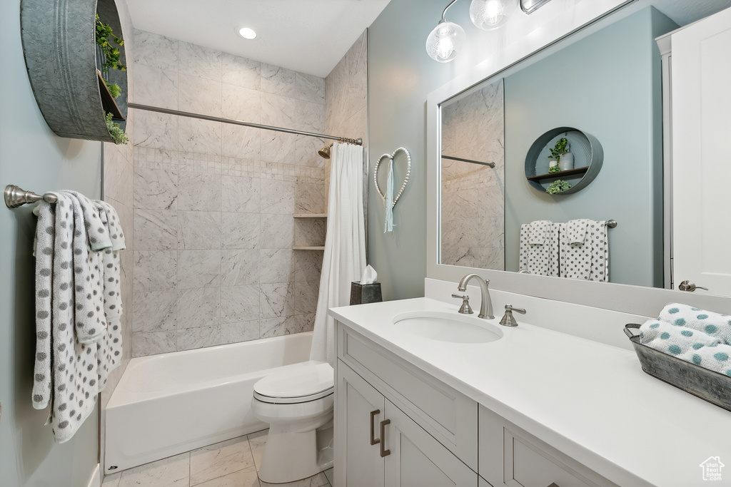 Full bathroom with vanity, tile patterned flooring, toilet, and shower / bath combo