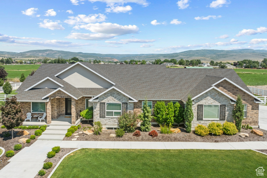 View of front of home featuring a mountain view and a front lawn