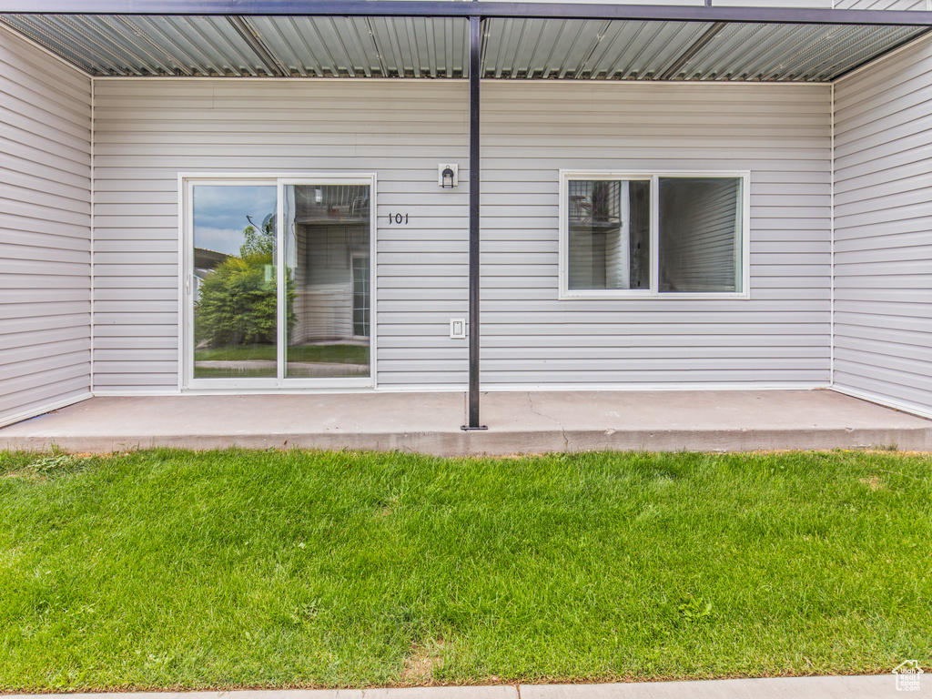 View of exterior entry featuring a lawn