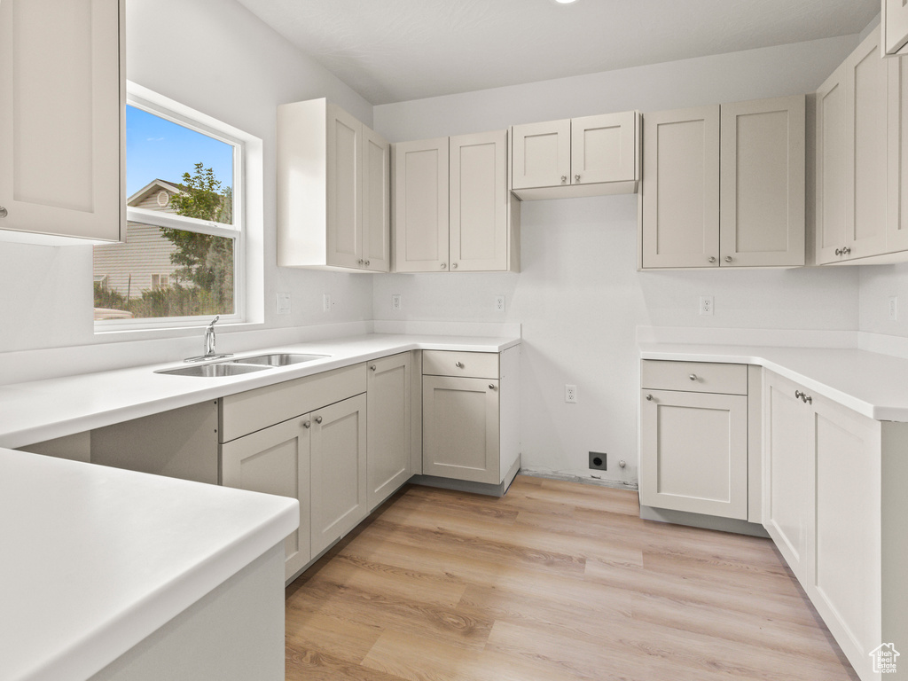 Kitchen with light hardwood / wood-style floors and sink