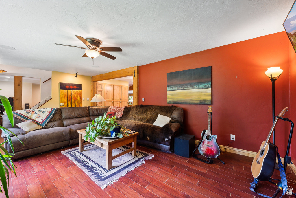 Living room featuring a textured ceiling, ceiling fan, and hardwood / wood-style floors