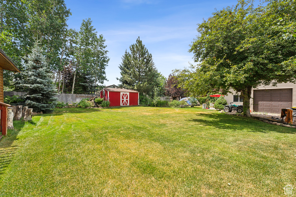 View of yard featuring a shed and a garage