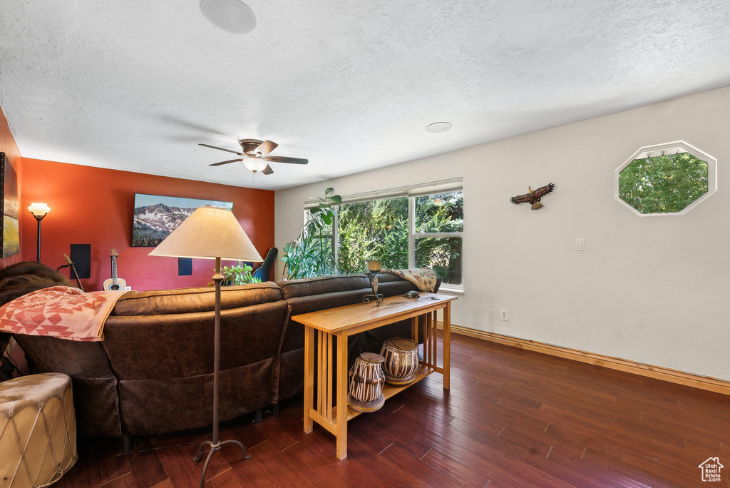 Living room with hardwood / wood-style flooring, a textured ceiling, and ceiling fan