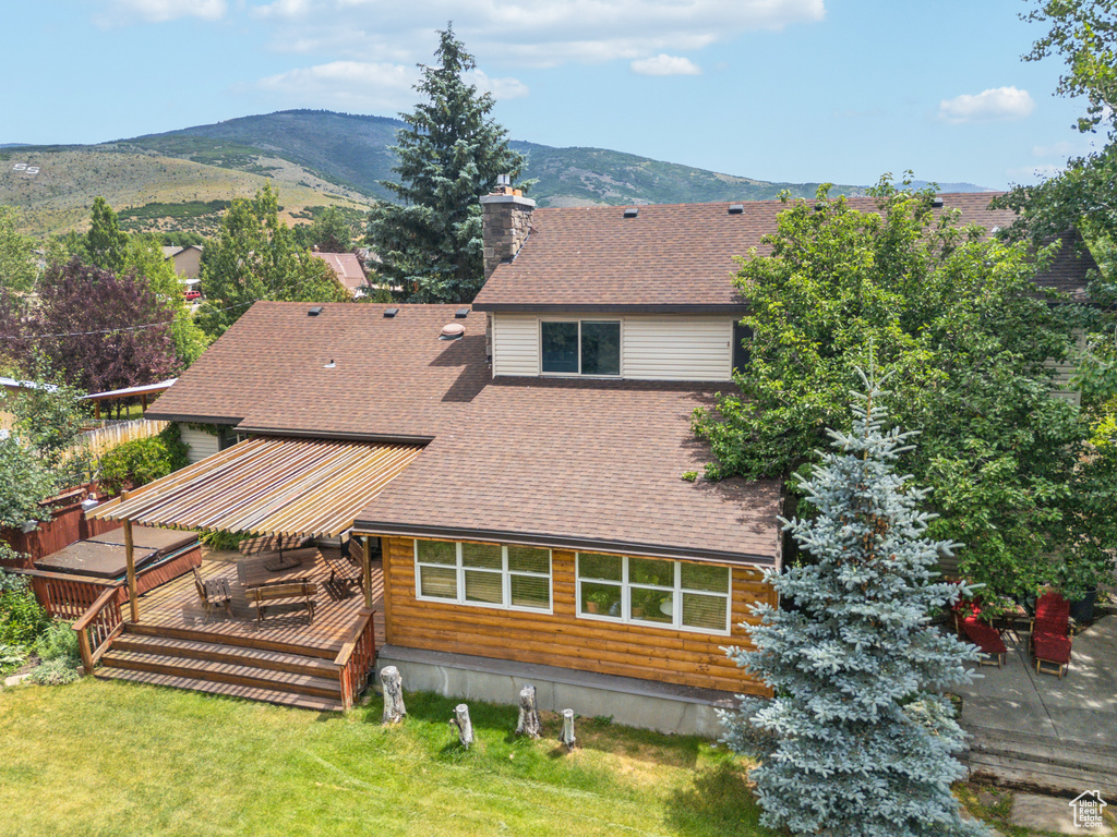 Exterior space featuring a deck with mountain view and a lawn