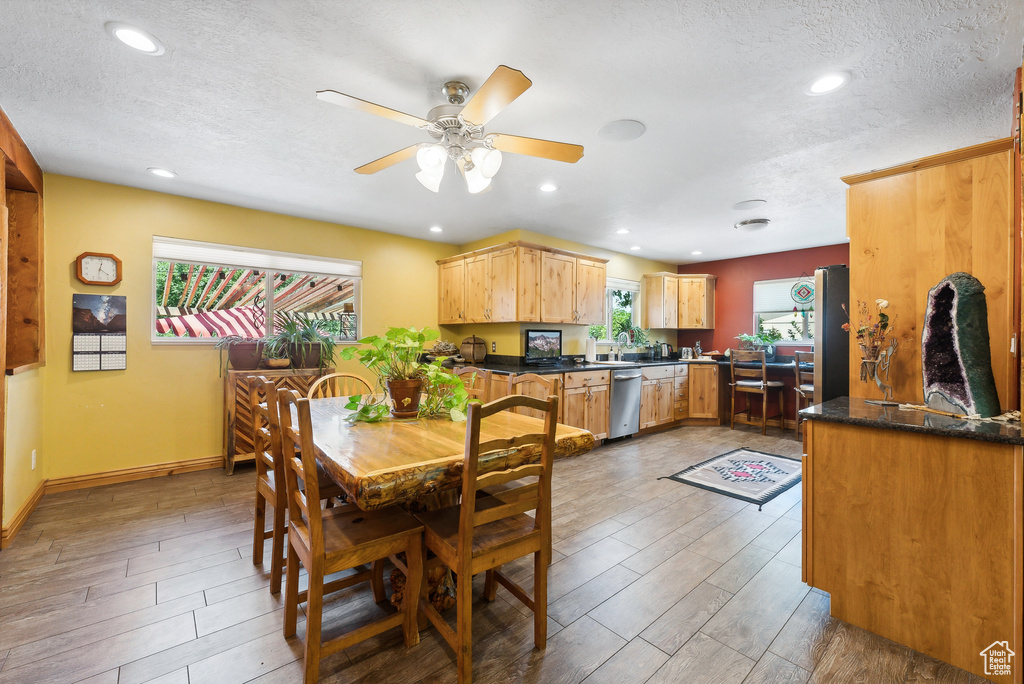 Dining space featuring a textured ceiling, light wood-type flooring, and ceiling fan