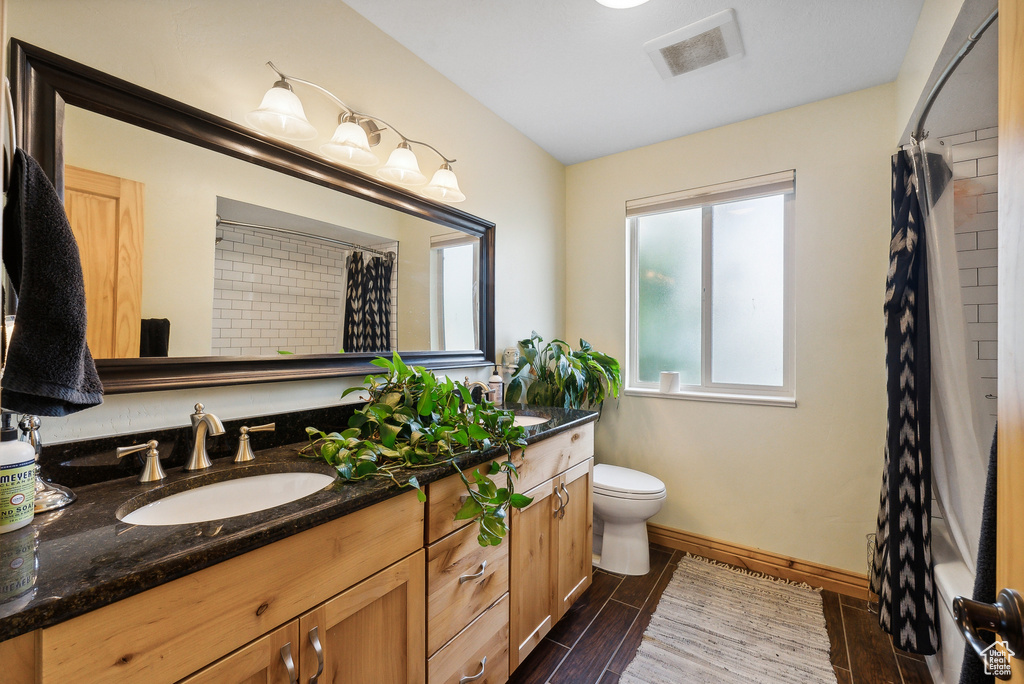 Bathroom featuring vanity, tile patterned floors, and toilet