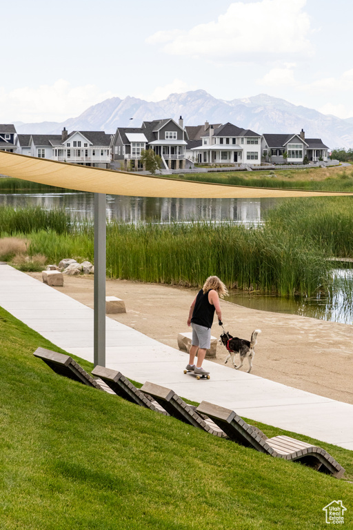 View of dock featuring a water and mountain view and a lawn