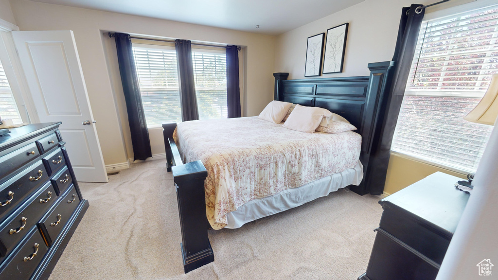 Carpeted bedroom featuring multiple windows