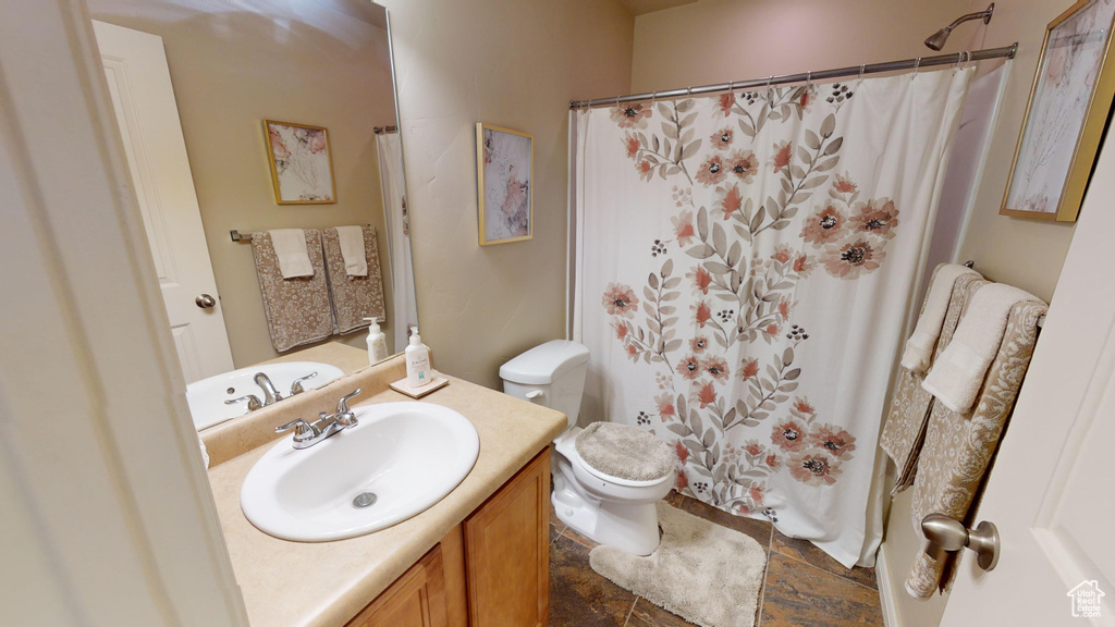 Bathroom with vanity, toilet, and tile patterned floors