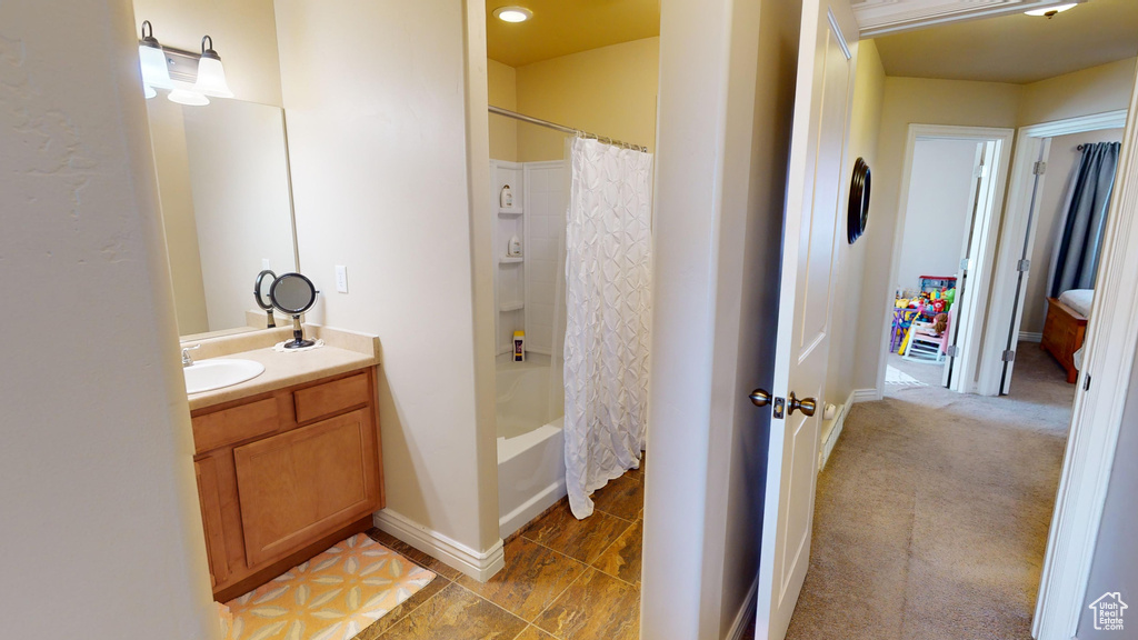 Bathroom featuring shower / tub combo, tile patterned floors, and vanity