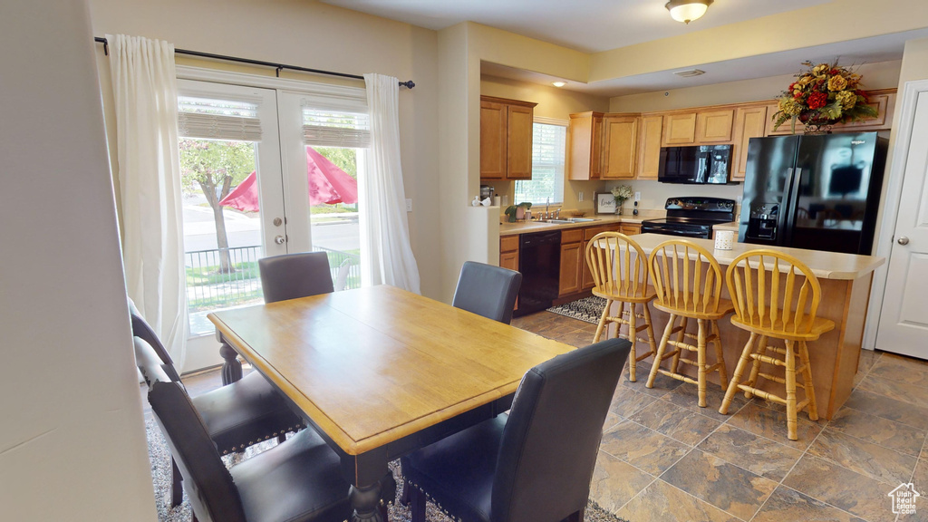 Tiled dining space with sink and french doors