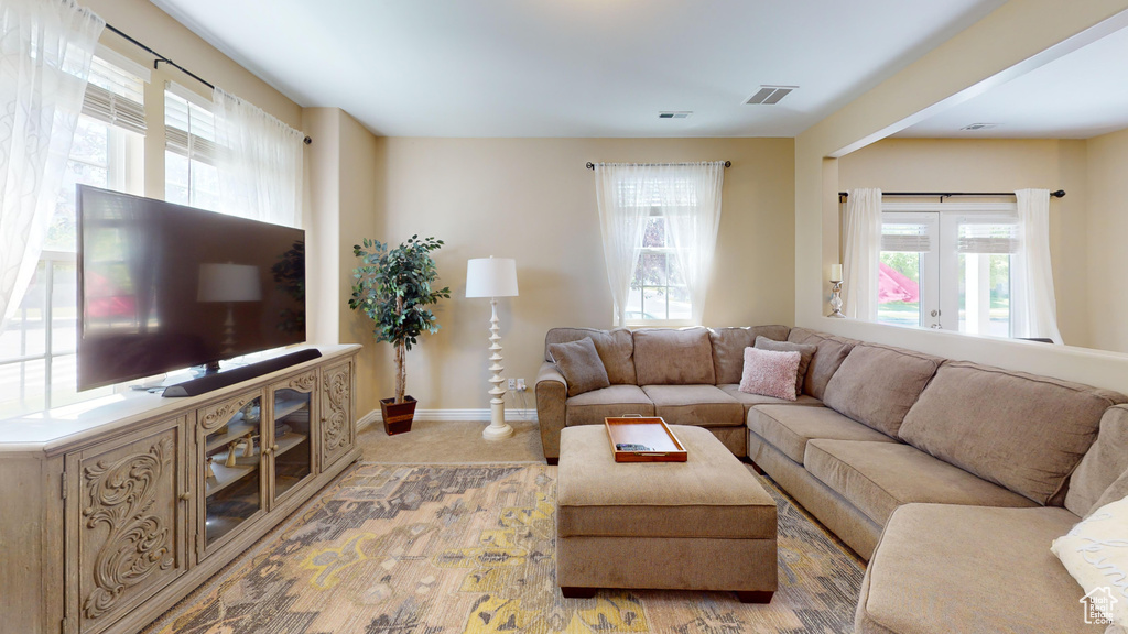 Carpeted living room featuring french doors