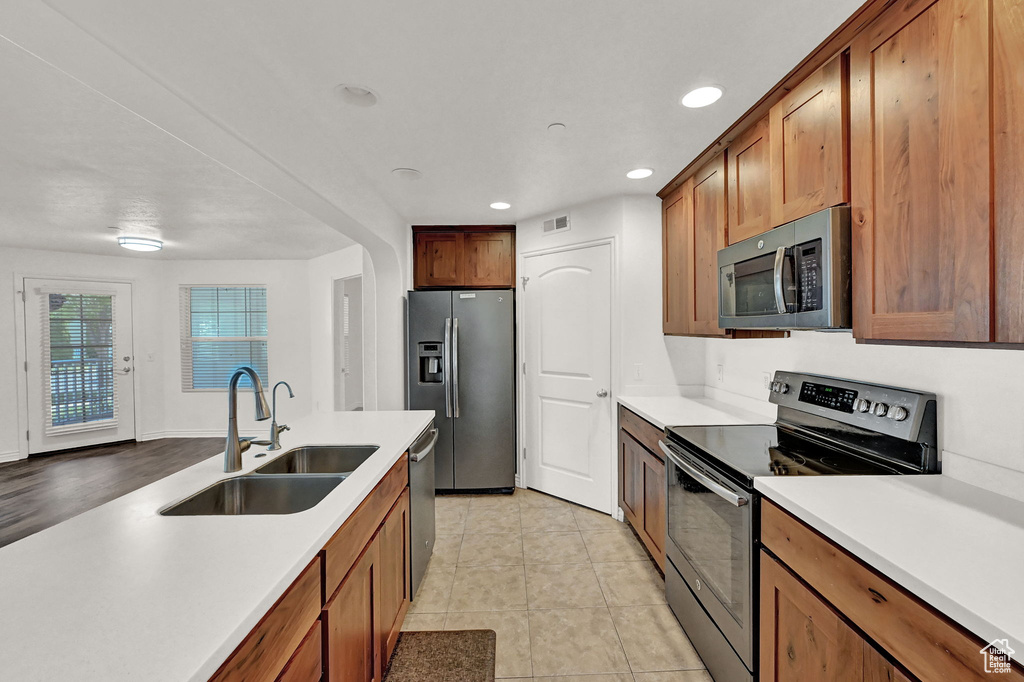 Kitchen featuring sink, appliances with stainless steel finishes, and light hardwood / wood-style floors