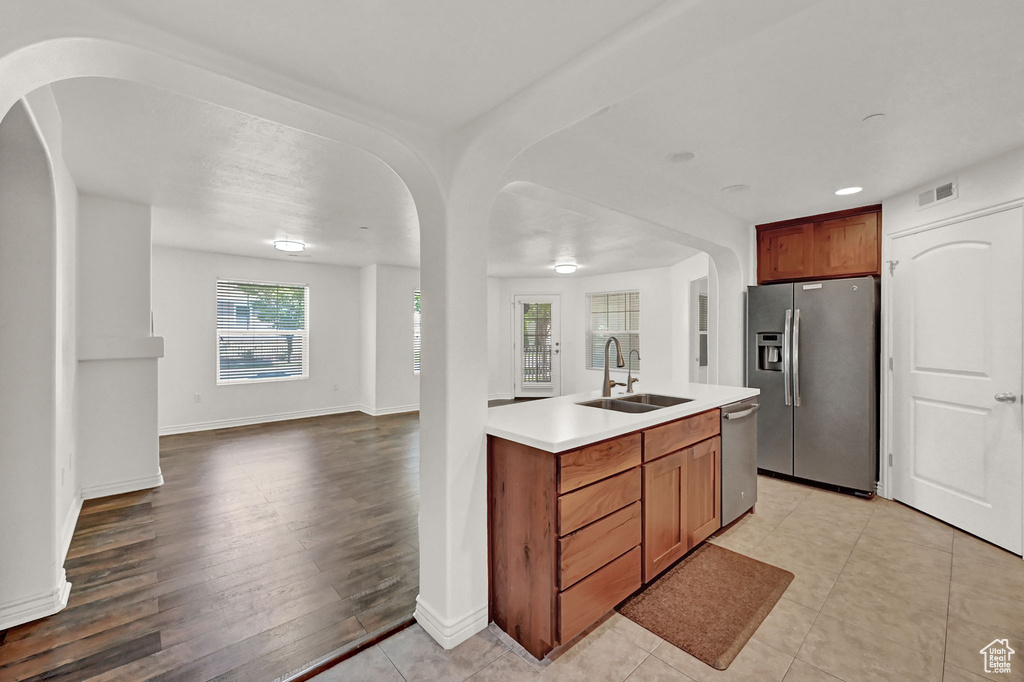 Kitchen with sink, light hardwood / wood-style flooring, and stainless steel appliances