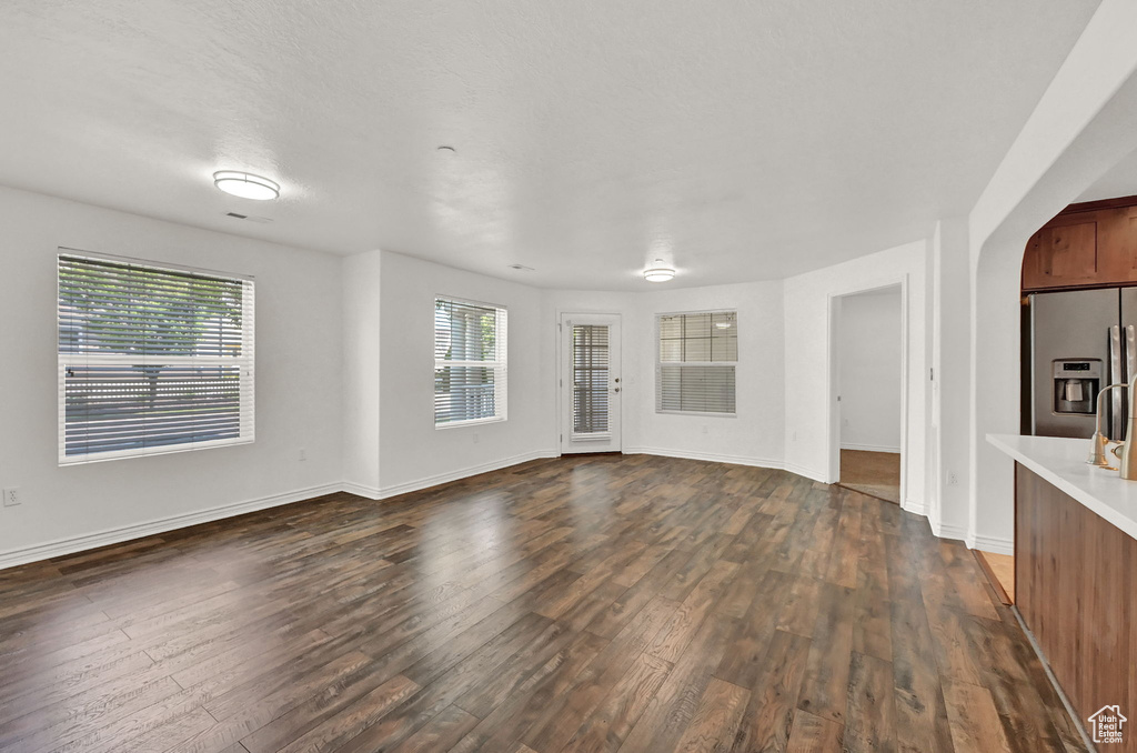 Unfurnished living room with dark wood-type flooring