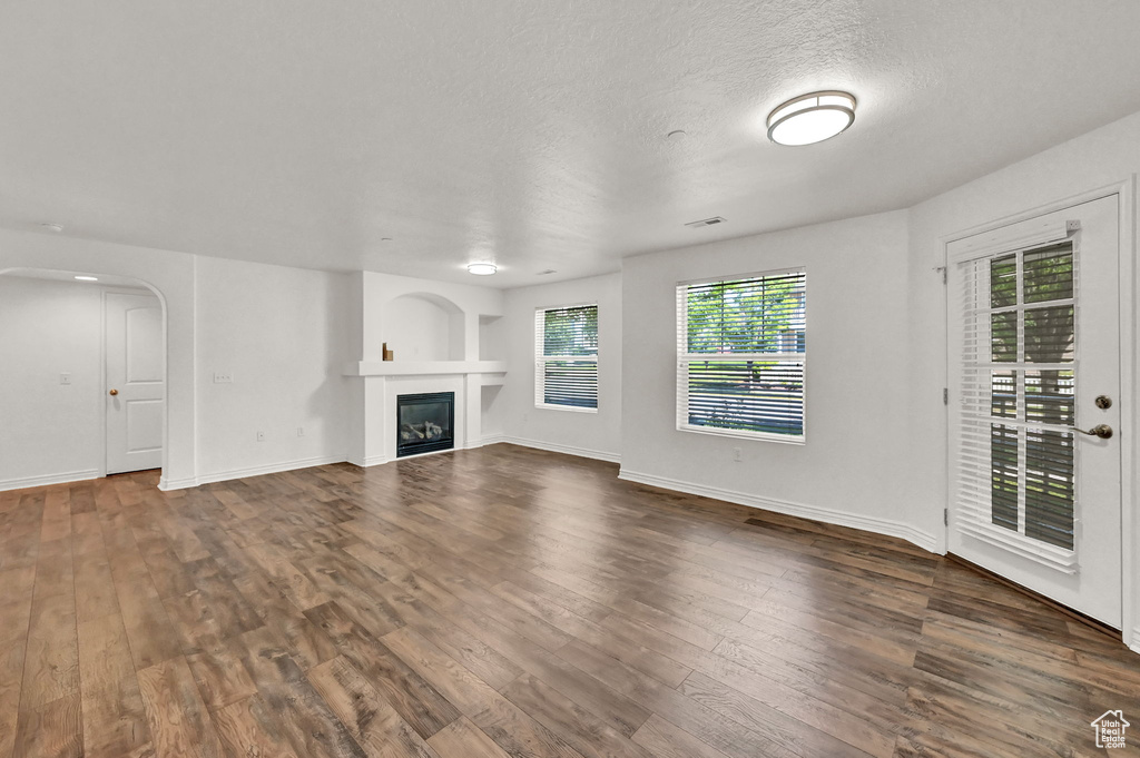 Unfurnished living room with a textured ceiling and wood-type flooring