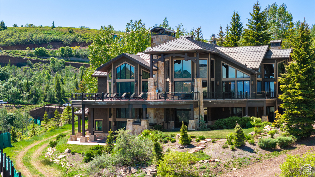 Rear view of house with a balcony and a patio area