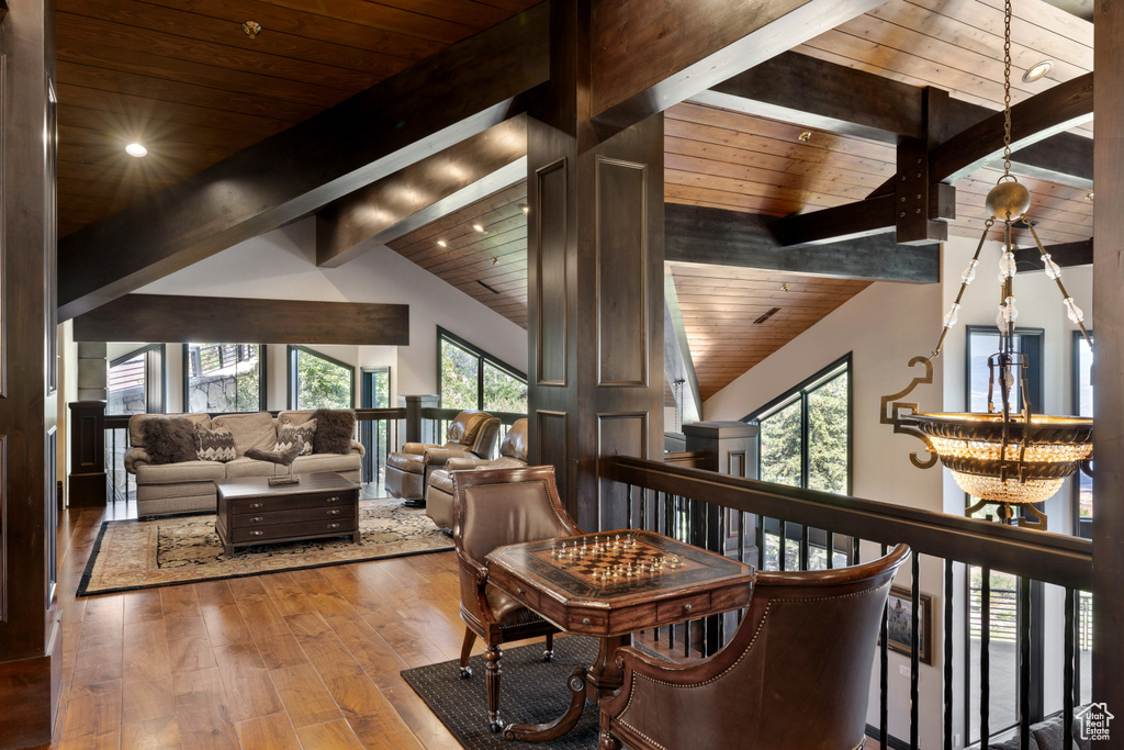 Interior space with vaulted ceiling with beams, wooden ceiling, and hardwood / wood-style floors