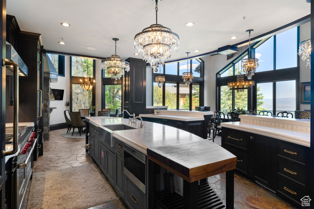 Kitchen featuring a notable chandelier, tile patterned floors, hanging light fixtures, double oven range, and sink