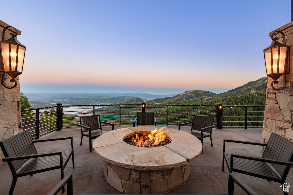 Patio terrace at dusk featuring a mountain view and an outdoor fire pit