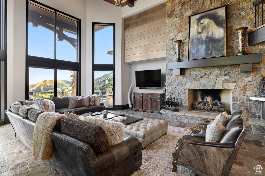 Living room with a high ceiling, a fireplace, and a mountain view