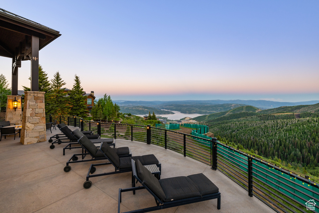 Patio terrace at dusk featuring a balcony