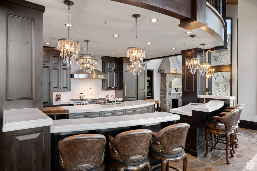 Kitchen featuring hanging light fixtures, a notable chandelier, decorative backsplash, and a large island