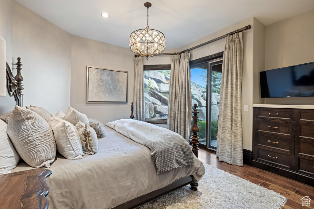 Bedroom featuring a notable chandelier, access to outside, and dark hardwood / wood-style floors