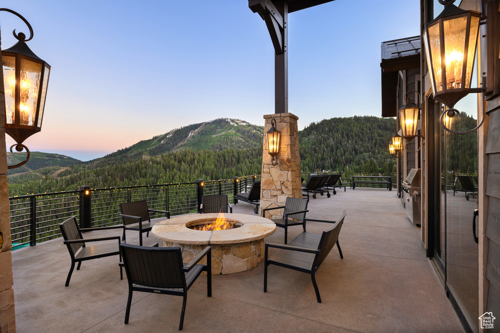 Patio terrace at dusk with a mountain view and an outdoor fire pit