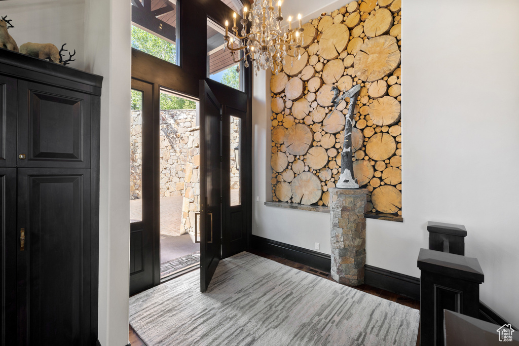 Entryway featuring an inviting chandelier and wood-type flooring