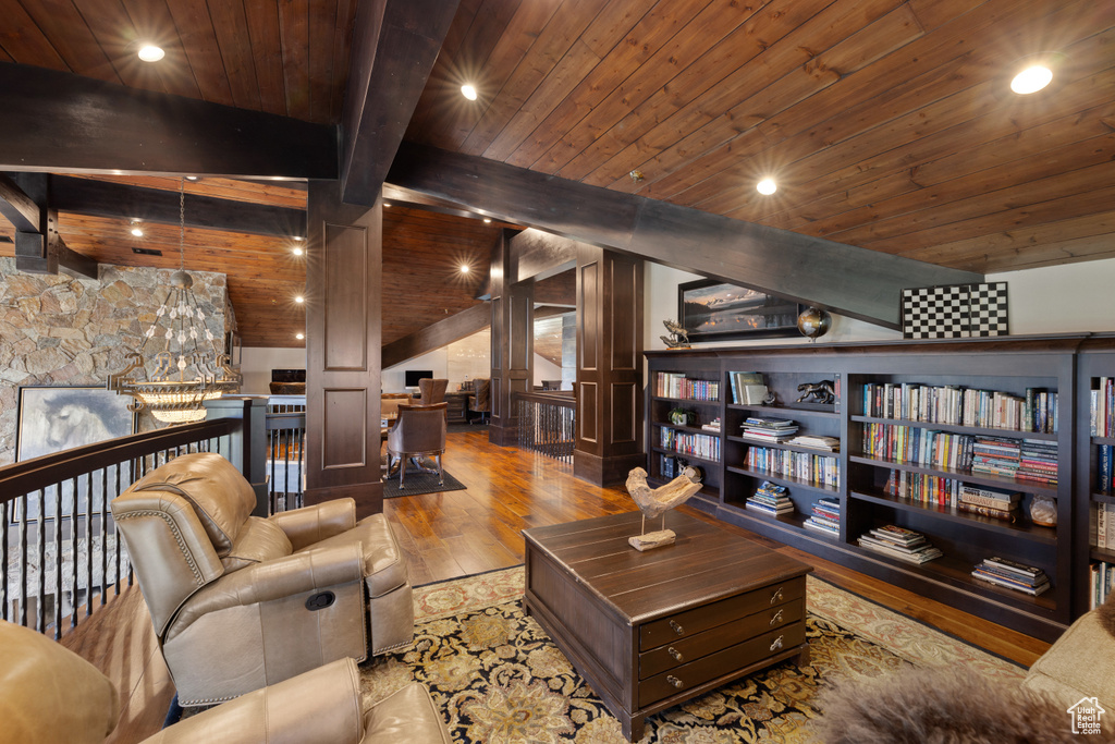 Living room with vaulted ceiling with beams, wood ceiling, and light hardwood / wood-style flooring