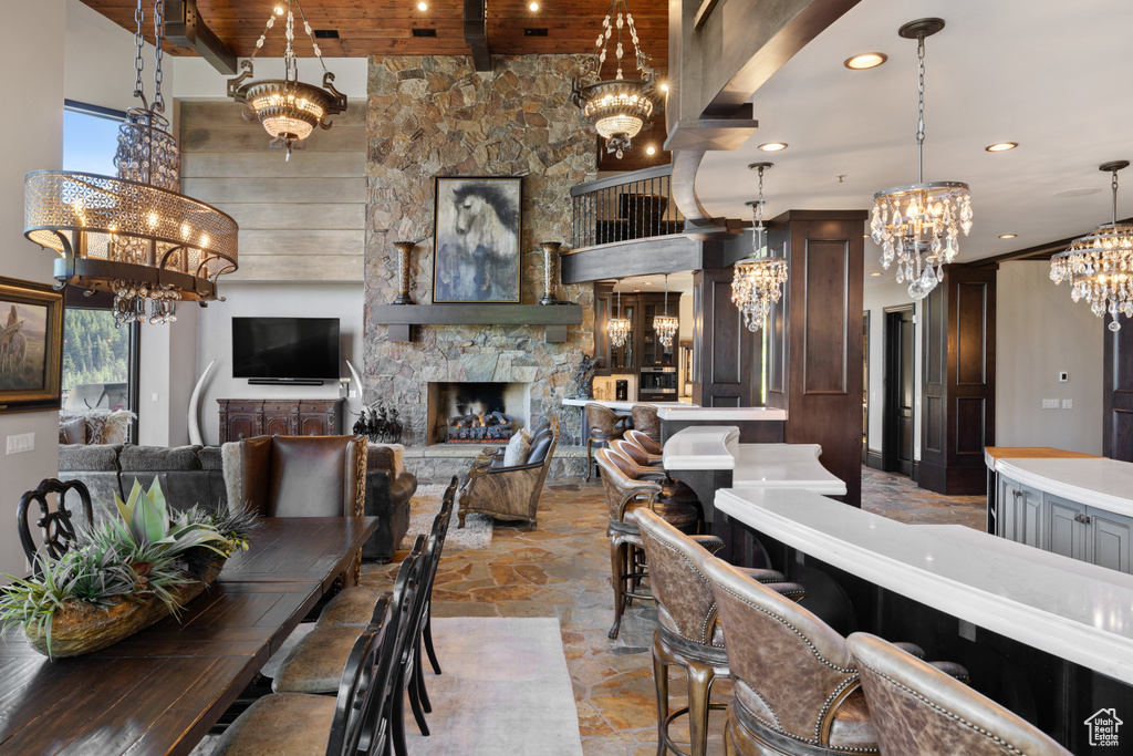 Dining space featuring plenty of natural light, a stone fireplace, a high ceiling, and light tile patterned floors