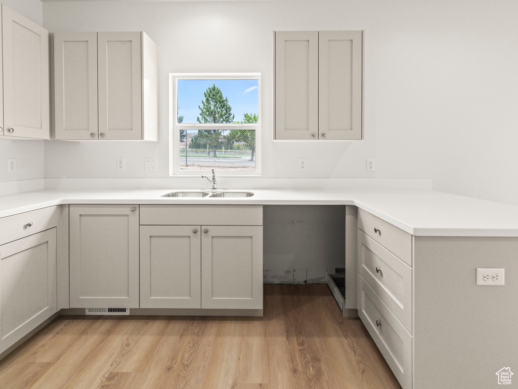 Kitchen with light wood-type flooring and gray cabinets