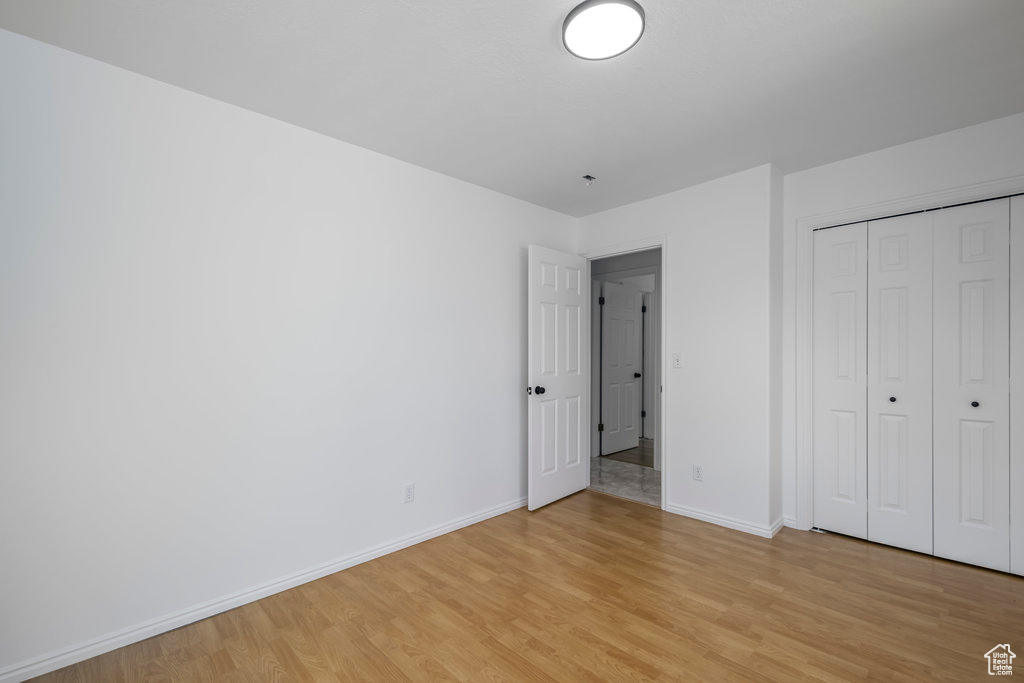 Unfurnished bedroom with a closet and light wood-type flooring