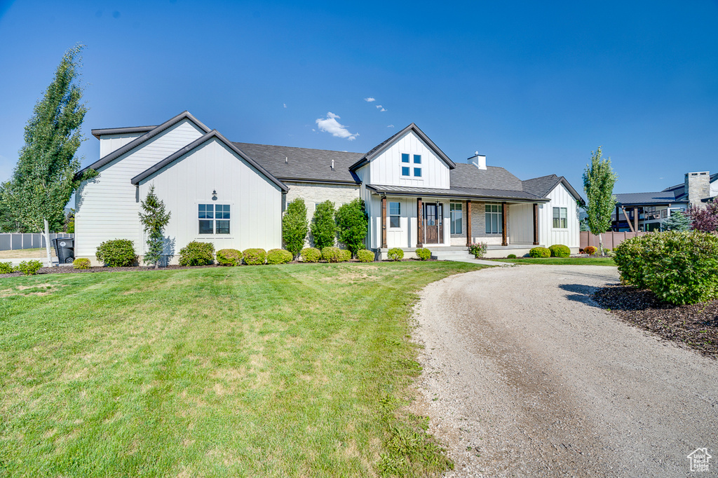 View of front of home with a porch and a front lawn