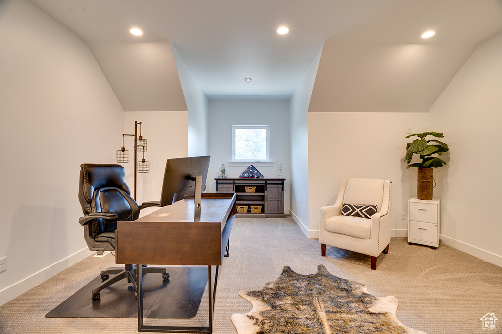 Carpeted office space with lofted ceiling