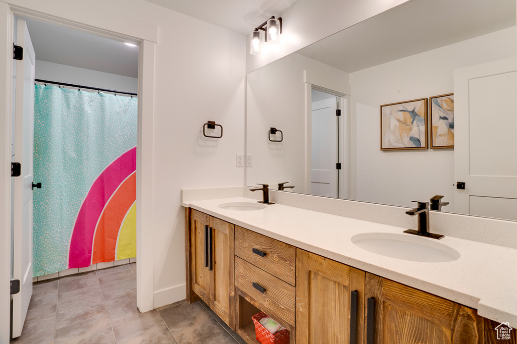 Bathroom with tile patterned floors and double sink vanity