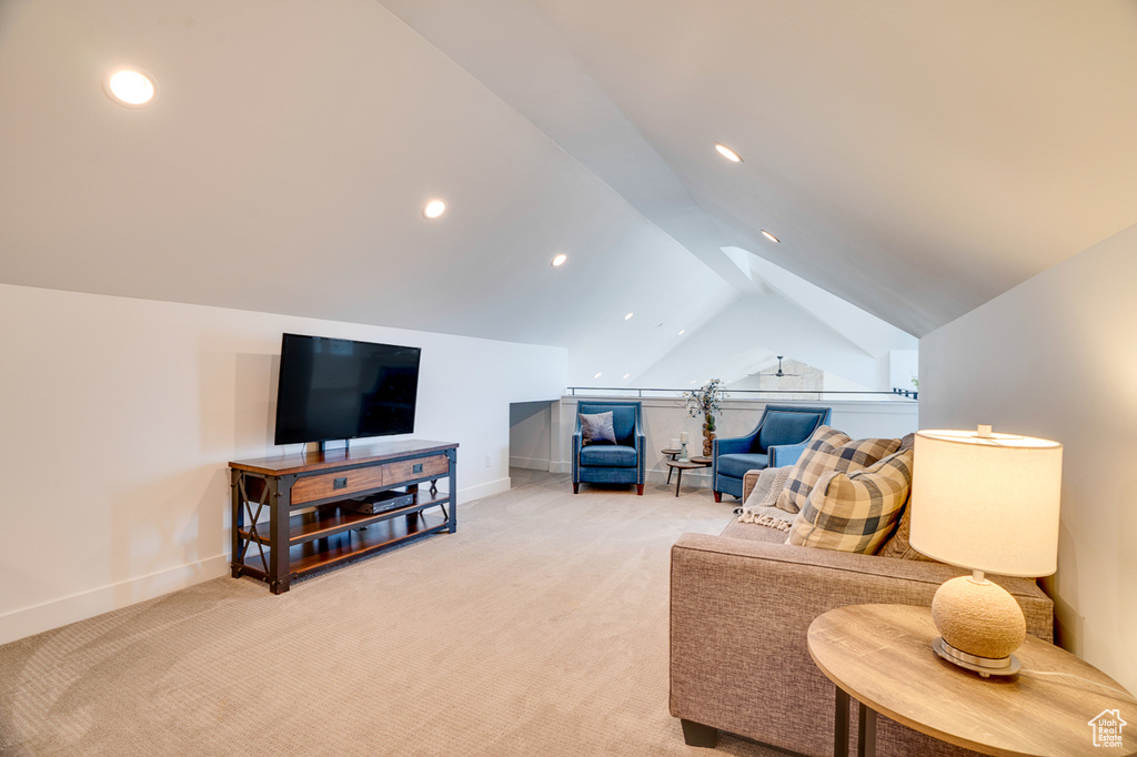 Carpeted living room featuring vaulted ceiling