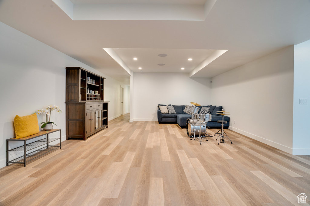 Living area with light hardwood / wood-style floors and a tray ceiling