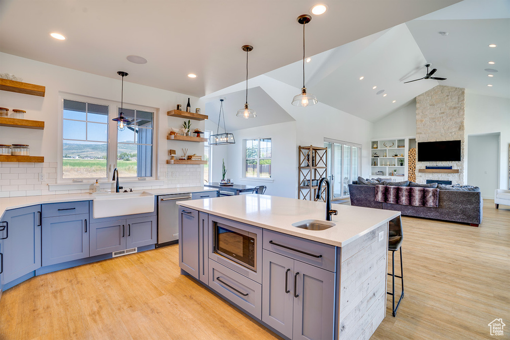 Kitchen featuring sink, appliances with stainless steel finishes, light wood-type flooring, and ceiling fan