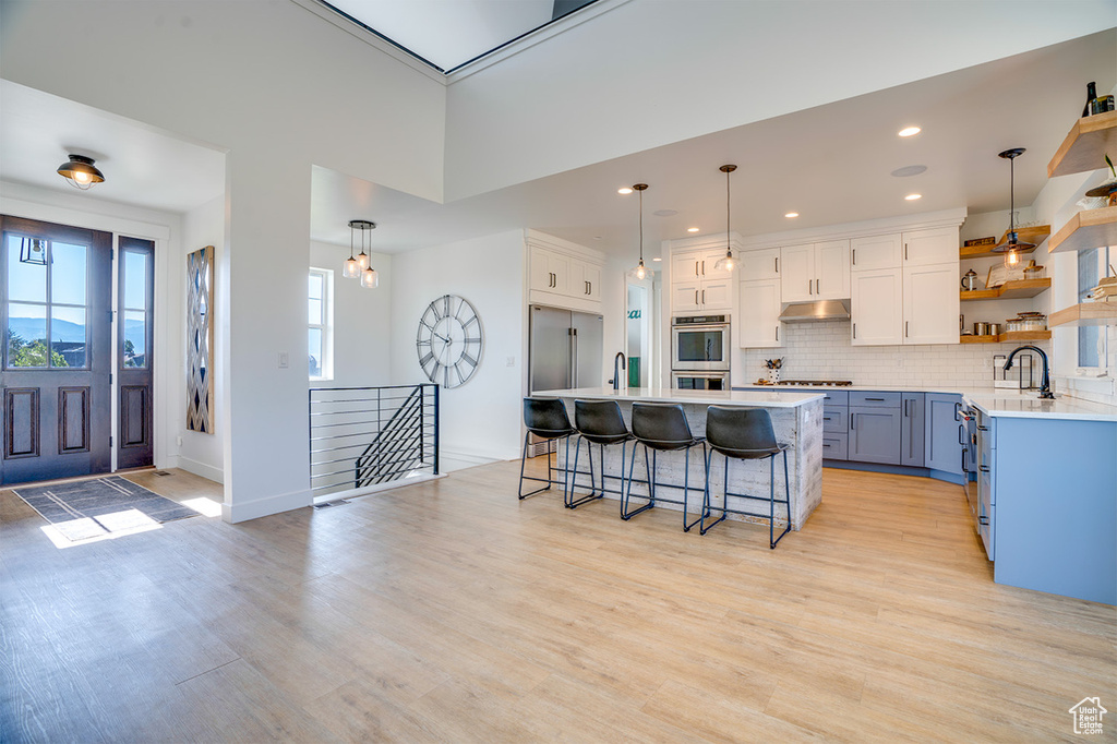 Kitchen featuring plenty of natural light, white cabinetry, pendant lighting, and stainless steel appliances