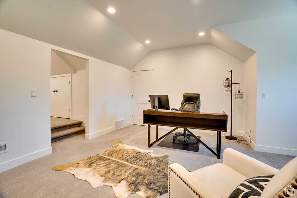 Carpeted home office featuring lofted ceiling