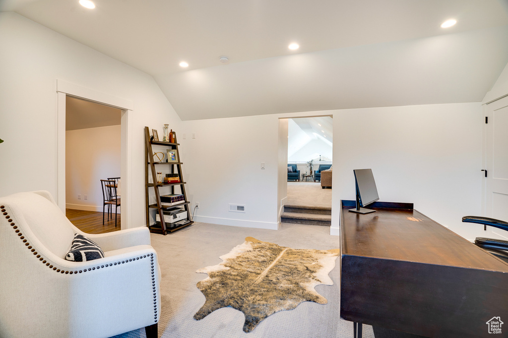 Carpeted office space with vaulted ceiling